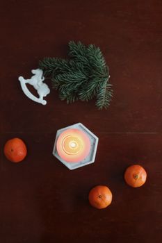 Christmas Toy horse, candle, tangerines and pine cone. Winter holiday items for home decor. Flat lay stock photography.