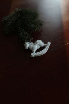 Christmas tree, toy horse, gift box, pine cone on a wooden table background top view. New Year home decoration. Festive design