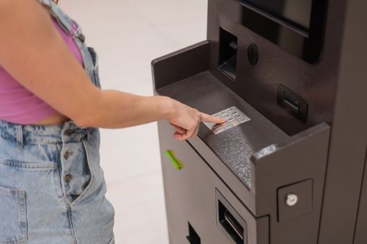 Faceless woman dialing bank card pin at ATM