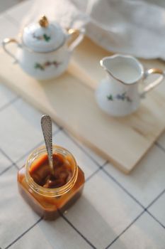 Homemade salted caramel sauce in jar on rustic wooden table
