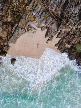 Drone aerial view at Freedom beach in Phuket Thailand, men laying down on a beach in bay at Phuket