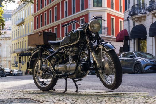 Black retro motorcycle parked in downtown of Lisbon