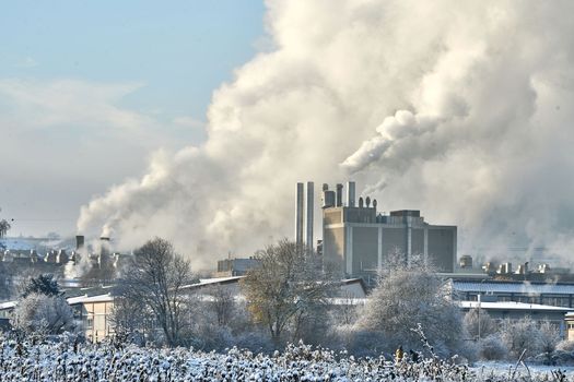 Environmental problem of pollution of environment and air in cities. Smoking industrial zone factory chimneys. View of large plant with Smoking pipes Smoke from the paper industry, which is running every day of the year. Photo taken December 2022 Air pollution in the city. Smoke from the chimney on blue sky background. High quality photo