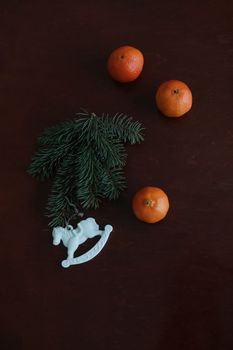 Christmas Toy horse, tangerines and pine cone. Winter holiday items for home decor. Flat lay stock photography.