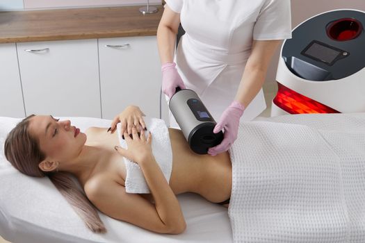 Endosphere therapy of female body by a cosmetologist in beauty salon