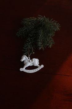 Christmas tree, toy horse, gift box, pine cone on a wooden table background top view. New Year home decoration. Festive design