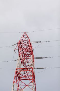 Red high Pylon high-voltage power lines, high voltage electric transmission tower for producing electricity at high voltage electricity poles at the sunset.