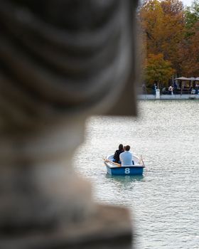 Young couple relaxed taking a selfie in a lake in autumn. Madrid , retiro park