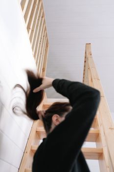 Young woman simple hairstyle against wooden stairs. Depression, loneliness and quarantine concept. Mental health, Self care, staying home