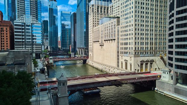 Image of Chicago river ship canal with multiple bridges and reflective glass skyscrapers