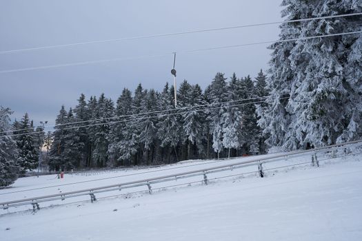 Ski lift station in the snow in the winter forest on the Wasserkuppe mountain in Rhen, Hesse, Germany. High quality photo