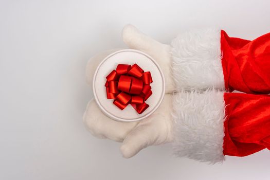 Santa's hands are holding a gift for Christmas. white background with space to copy. Christmas time