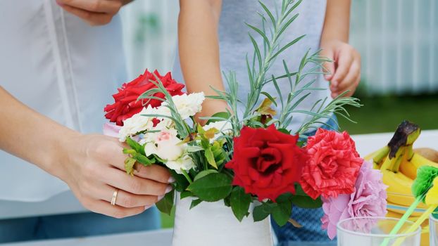 summer, in the garden, close-up. Mom with a four-year-old son make a bouquet of flowers. The boy likes it very much, he is happy,The family spends their leisure time together. High quality photo