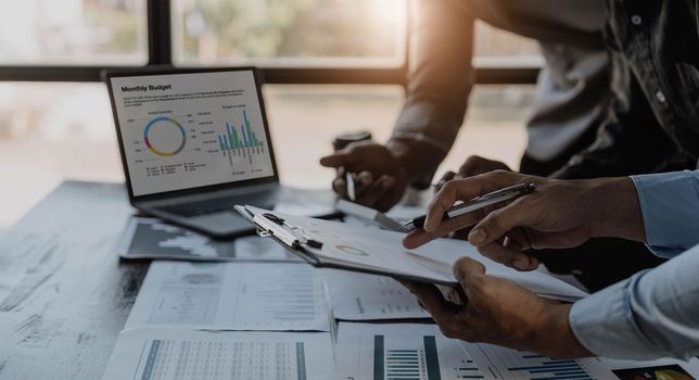 Business People Meeting using laptop computer,calculator,notebook,stock market chart paper for analysis Plans to improve quality next month. Conference Discussion Corporate Concept...