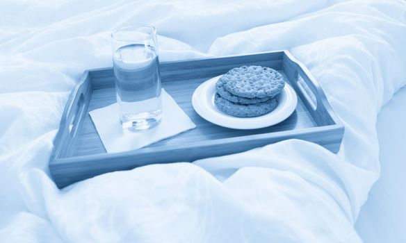 Tray with breakfast on a bed in a hotel room