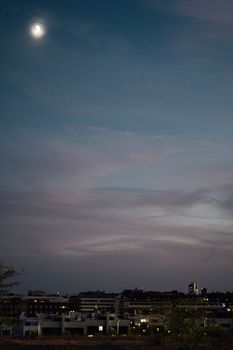 Skyline of Alcobendas with Madrid city center in the background at night. Sunset sky clouds and moon with copy space.