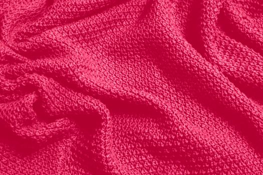 Viva Magenta toned colour monochrome texture knitted fabric. Dark pink knitted Jersey as textile background. Monochrome color background. Trendy color 2023.