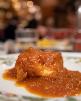 spanish cuisine, Bacalao a la vizcaina, Basque Style Cod in vertical. Restaurant background.