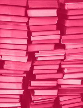 Viva Magenta colour chaotic stack of old books background. Background from old books that are exhibited in a chaotic manner. Colour of the year 2023. Trendy Viva Magenta color. High quality photo