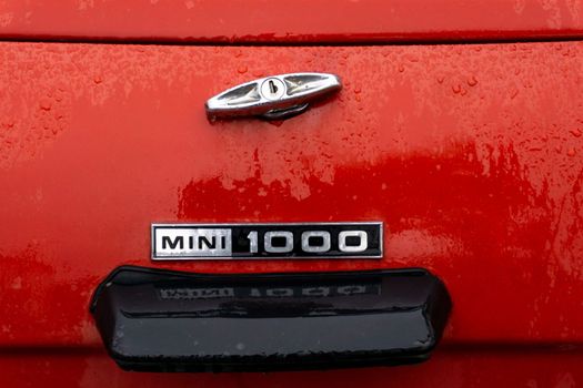 The trunk of a red retro car in raindrops close up