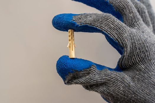 A worker's hand in a protective glove holds a plastic dowel pin on a white background. renovation in the bathroom. installation of bathroom accessories.