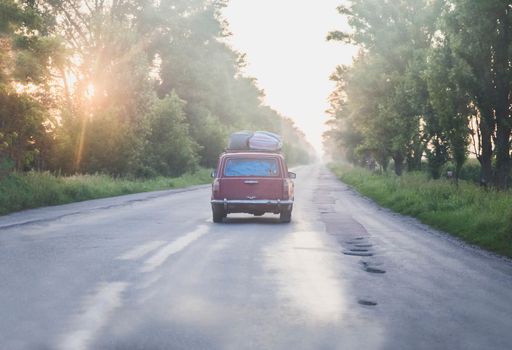 vintage Soviet car at sunrise on a broken desert road.