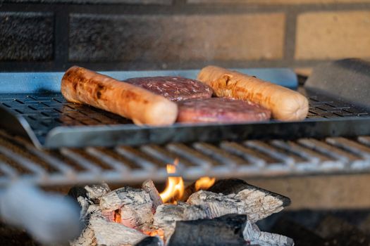 Close up of burgers and hotdogs barbecue. Family and friends weekend concepts.