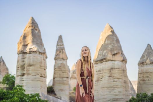 Woman tourist on background of Unique geological formations in Love Valley in Cappadocia, popular travel destination in Turkey.