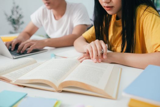 Young woman and man studying for a test or an exam. Tutor book with friends. Young students campus or classmates helps friend catching up workbook and learning tutoring in classroom, teaching, learning