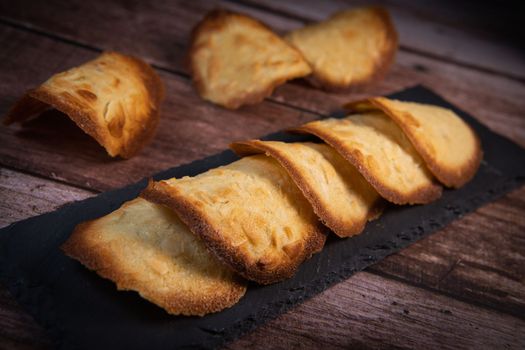 French delicacy pastry tuile with almond on wood background, High quality photo