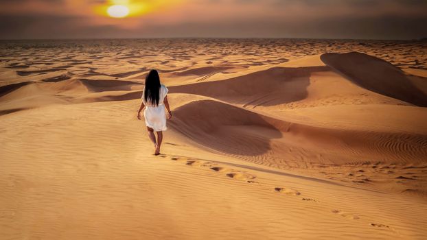 Dubai dessert sand dunes, Asian women on Dubai desert safari,United Arab Emirates, woman vacation in Dubai visit the sand dunes