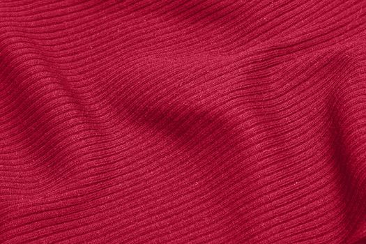 Viva Magenta toned colour monochrome texture knitted fabric. Dark pink knitted Jersey as textile background. Monochrome color background. Trendy color 2023.