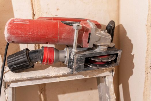 professional construction power tool for cutting grooves in concrete during the renovation of the apartment. A hand-held power tool with two diamond discs for cutting grooves in the wall for laying electrics. Professional tool. Close-up