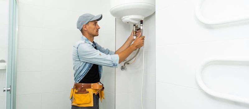 Plumber repairing an hot-water heater.