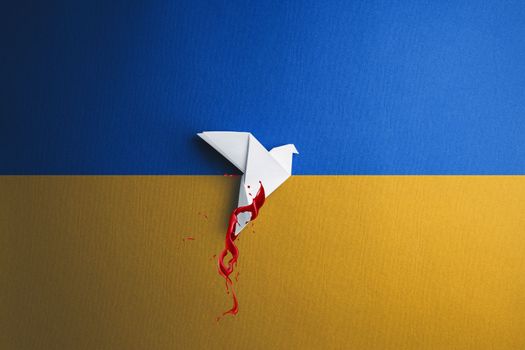 white paper origami dove bird in blood takes off and breaks free, on yellow blue background in color of ukraine flag. concept needs help and support, truth will win