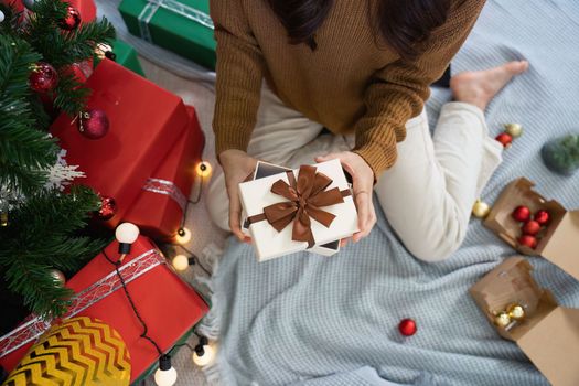 Cheerful lady surprised of the present after the opening in the gift box. Marry Christmas and Happy Holidays and New Year eve celebrating concept.