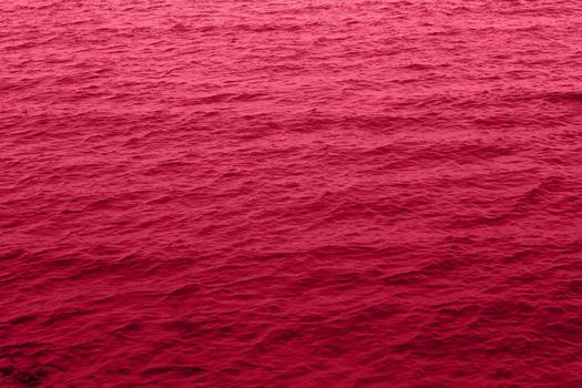 Viva Magenta toned sea water texture. Pool water with sun reflections. Trendy colour 2023 year. High quality photo