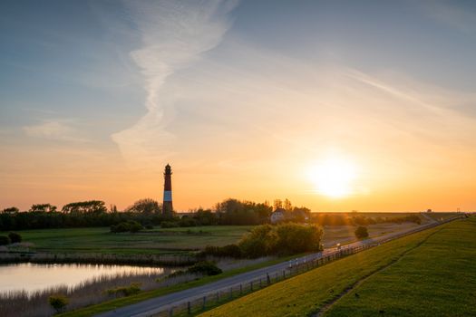 Panoramic image of Pellworm lighthouse against sunrise, North Frisia, Germany 