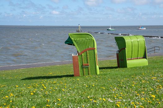 Panoramic image of the landscape along the dikes of Pellworm with beach chairs, North Frisia, Germany 