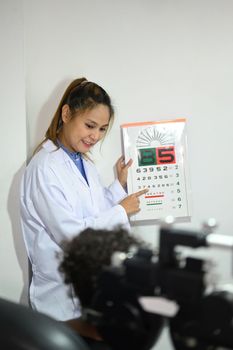 Shot of ophthalmologist checking child eyesight with ophthalmology measurements letters, for testing visual acuity.