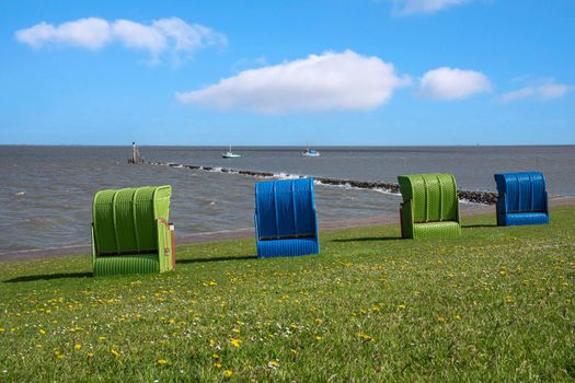 Panoramic image of the landscape along the dikes of Pellworm with beach chairs, North Frisia, Germany 