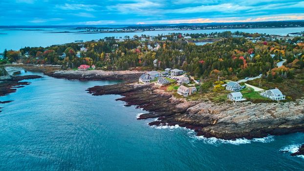 Image of Dusk light aerial over coast of Maine with rocky cliffs and homes