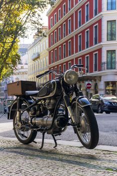Black retro motorcycle parked in downtown of Lisbon