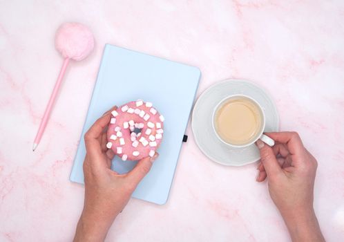 the concept of proper nutrition, the girl calculates in a notebook the calories of a donut and a cup of coffee, High quality photo