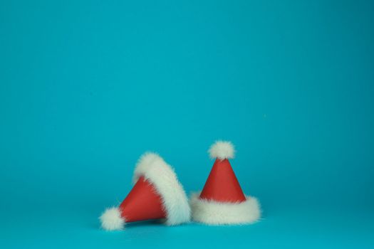 two Santa Claus's red with white feather hats on green background. Minimal styled card. High quality photo