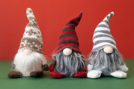 three little christmas gnomes gonks on red background. High quality photo