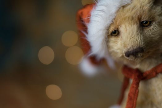 Christmas card greeting with cute handmade teddy bear with red Santa cap on brown background. high quality photo