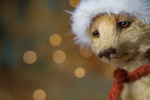 Christmas card greeting with cute handmade teddy bear with red Santa cap on brown background. high quality photo