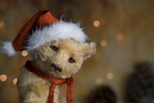 Christmas card greeting with cute handmade teddy bear with red Santa cap on brown background. high quality photo