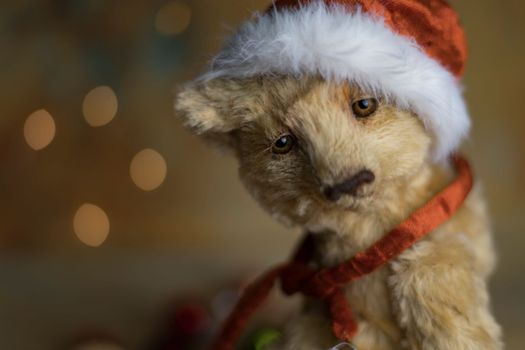 Christmas card greeting with cute handmade teddy bear with red Santa cap on brown background. high quality photo